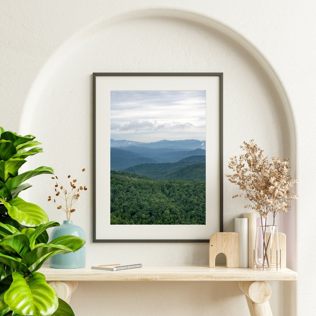 Framed landscape print of the Blue Ridge Mountains on a shelf with decorative items